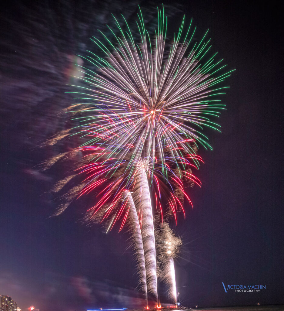 Spectacular red, green, and white fireworks explode over Bal Harbour beach during a 4th of July celebration, photographed by Victoria Machin Photography.
