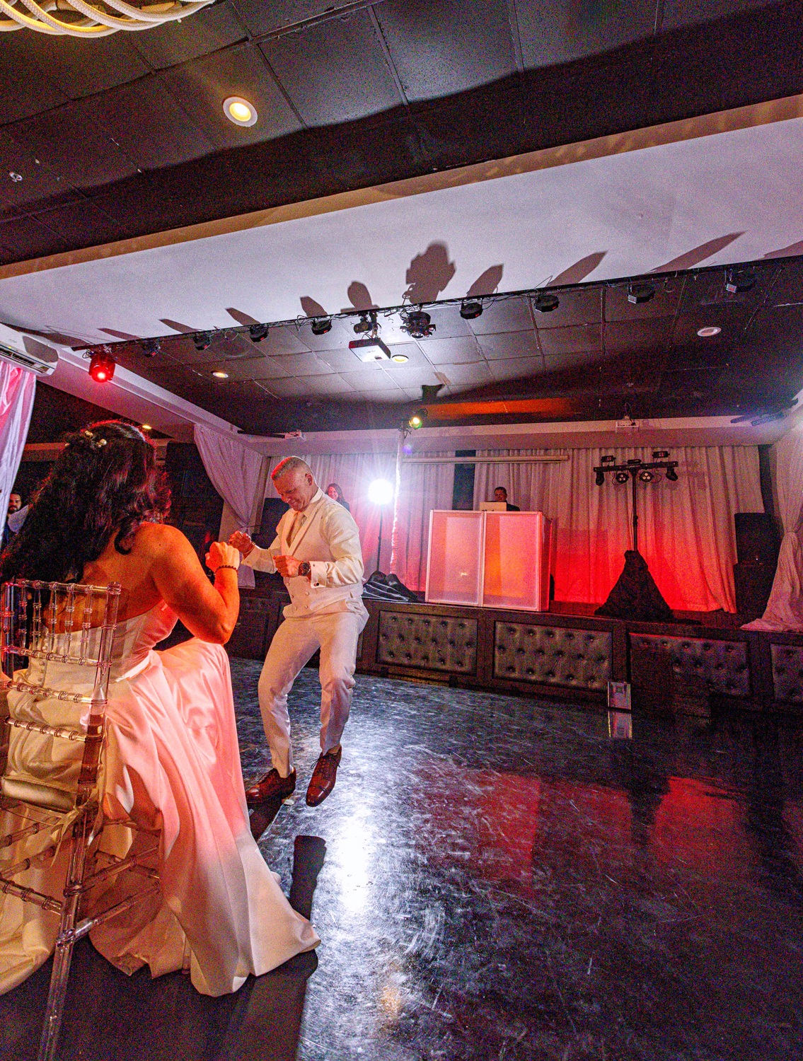 Groom performing a fun dance for his bride during the reception at Brisas On The Bay, with DJ lighting and uplighting by Zeta Event Productions.