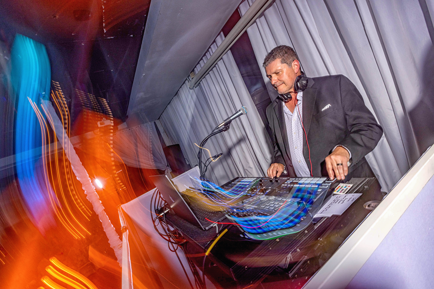 Zeta Event Productions DJ working the sound board with headphones on at Brisas On The Bay during a Miami wedding reception.